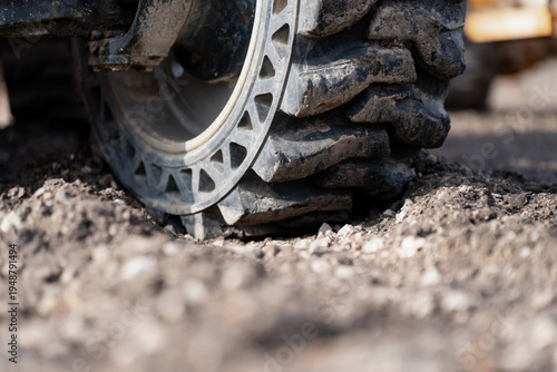 Tableau sur toile Heavy duty off road machinery tire pressed into gravel, highlighting ground trac