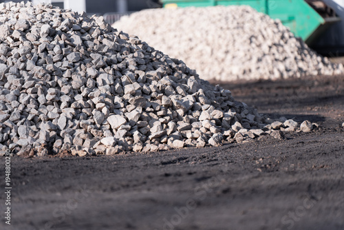 Tableau sur toile Pile of crushed stone on a construction site with another aggregate mound behind