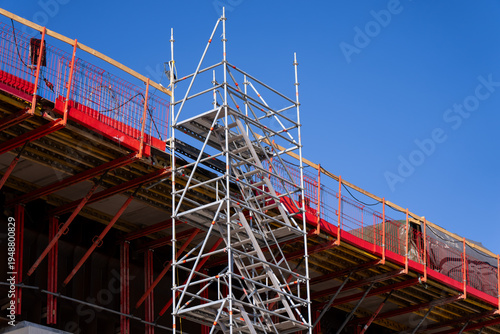 Photos Bridge construction platform with scaffold tower and red edge protection, repres