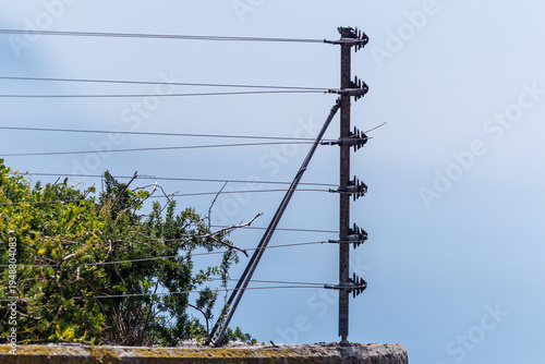 Electric security fence installed on residential building wall with insulators and wires