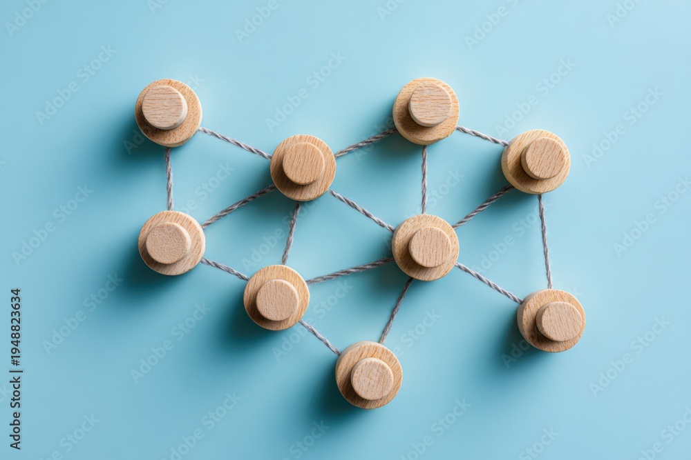 Fototapeta premium Interconnected Network: Abstract wooden objects linked together on a soft blue surface, symbolizing connectivity and network architecture.