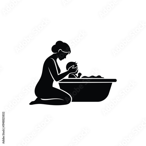 A silhouette of a mother bathing a baby in a rectangular tub a tender moment