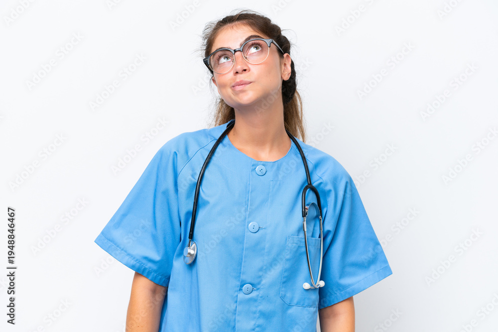 Fototapeta premium Young nurse doctor woman isolated on white background and looking up