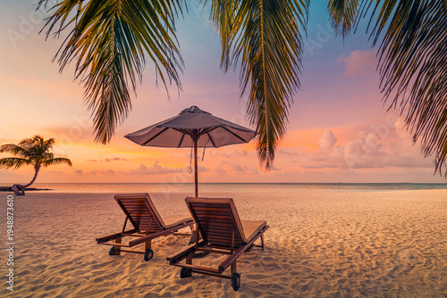 Romantic tropical beach sunset with sunbeds and umbrella, palm trees silhouette, ocean view, luxury honeymoon destination, peaceful summer vacation scenery