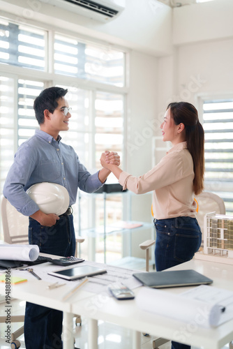 Asian architects engineers construction professionals handshake agreement office meeting project collaboration success business partnership achievement