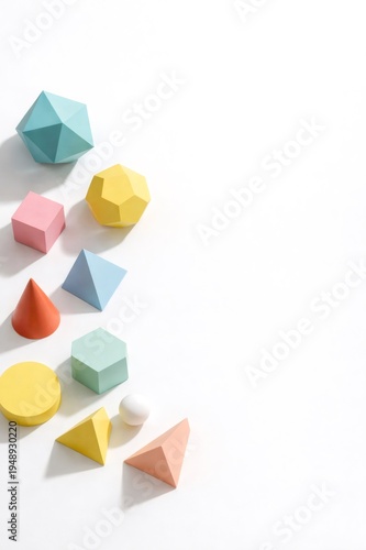Colorful geometric shapes are arranged abstractly on a bright white background, casting soft shadows and highlighting concepts of design, creativity, and mathematical principles