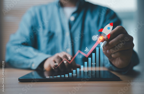 Businessman launching rocket over rising financial chart on digital tablet represent startup growth, business success, investment strategy, financial progress, profit increase development concept.