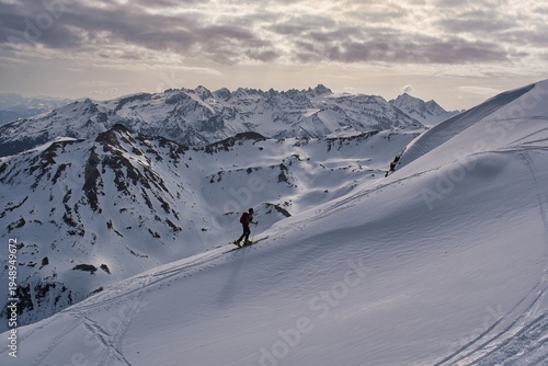  A ski tourer ascends the beautiful Swiss mountains. Ski mountaineering in winter. Climbing Mount Hochfinsler. High quality photo