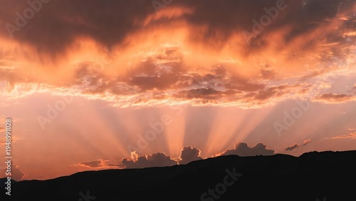 Breathtaking crepuscular rays pierce through dramatic clouds over a serene landscape.