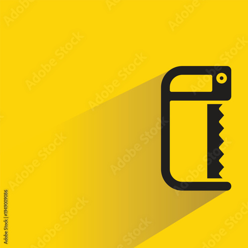 hand saw with shadow on yellow background