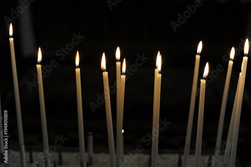 Burning candles in the dark chamber room of a church