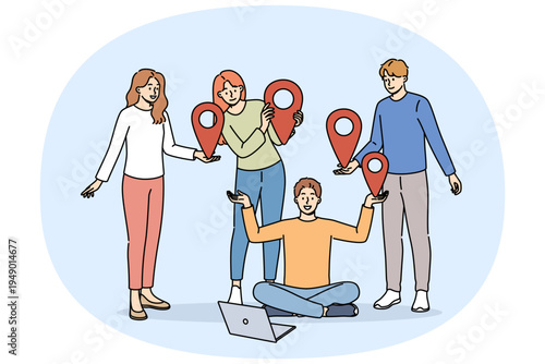 Team of students uses online communication on network, standing near laptop and holding red geotags in hands. Online communication technology for educational or professional purposes