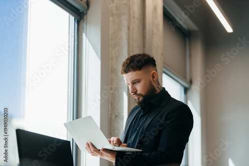 Obraz na plátne Young professional reviewing business data on laptop