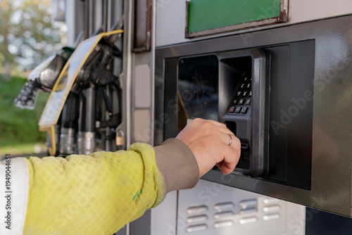 Customer pays at gas pump using credit card for fuel in the daytime