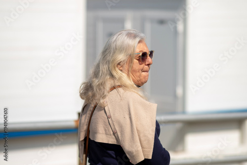 Cuadro en lienzo Seventy-year-old woman with long blonde hair pictured in profile walking outside
