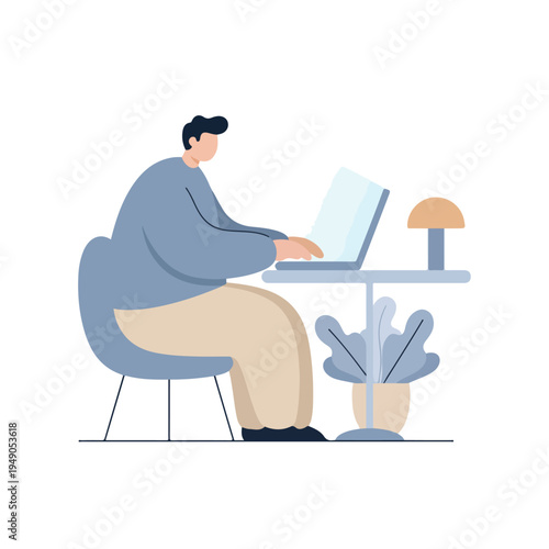 A man with dark hair sits in a blue chair at a light grey table, typing on a laptop, with a potted plant and a small lamp beside him.