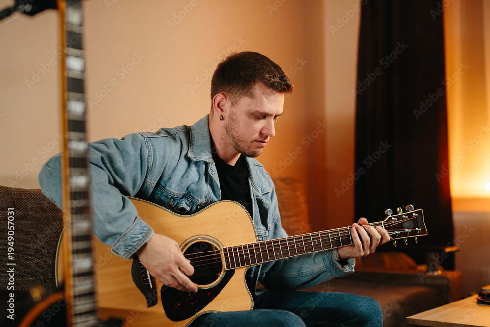 Obraz premium Musician composing music at home playing acoustic guitar