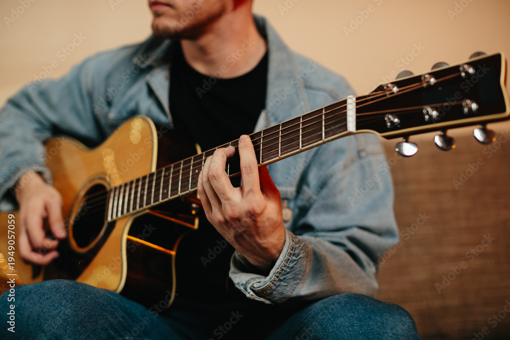 Obraz premium Young musician composing music playing acoustic guitar at home