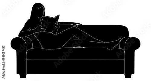 A woman relaxes and reads a book while lounging on a comfortable sofa