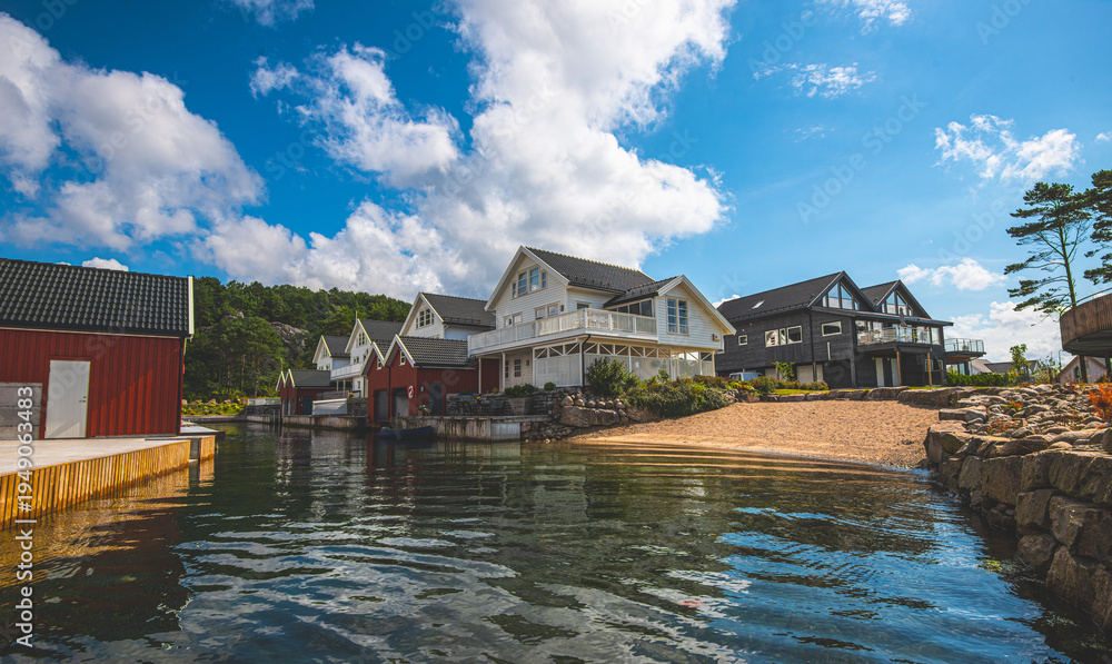 Obraz premium Scandinavian coastal houses reflected in calm harbor water.