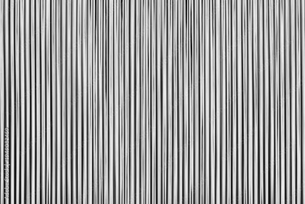 Fototapeta premium Vertical lines stretch across the frame, bold and stark. Black and white contrast creates a minimalist, graphic feel. The pattern pulses with rhythm, suggesting motion or sound