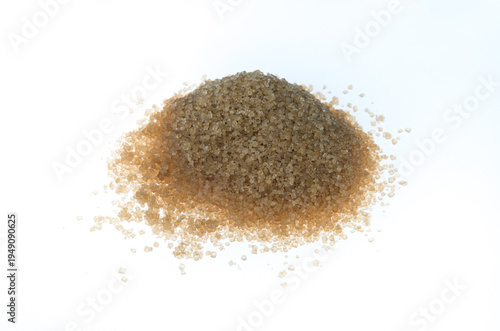 Foto A pyramidal pile of brown cane sugar form the side, on white background
