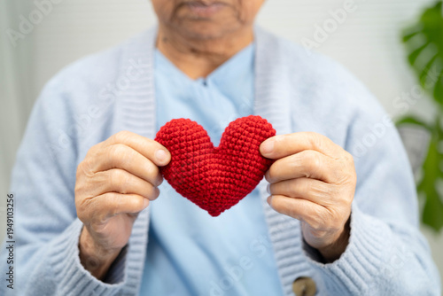 Schilderij op canvas Asian elder senior woman patient holding red heart in hospital.