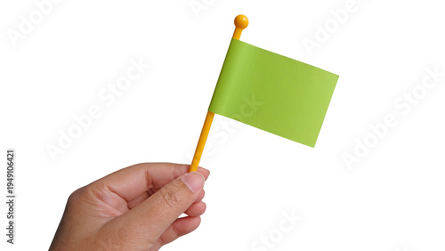 Hand holding a green flag isolated in white background. Danger warning, revolution and reach success concept.