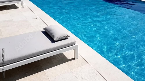 Tranquil poolside scene: Sun lounger and crystal-clear water creating a relaxing summer escape