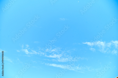 Light blue sky background with faint cirrus clouds and copy space