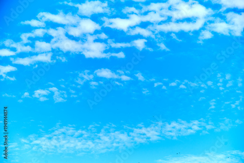 Blue sky background with scattered clouds and central copy space.