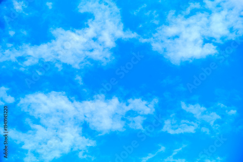 Blue sky background with scattered white clouds and ample copy space.