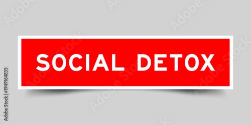 Red color square shape sticker label with word social detox on gray background