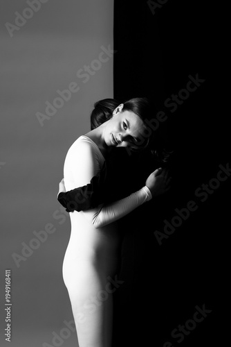 Zwei Frauen in schwarzem und weißen Overall umarmen sich vor schwarz-weißem Hintergrund