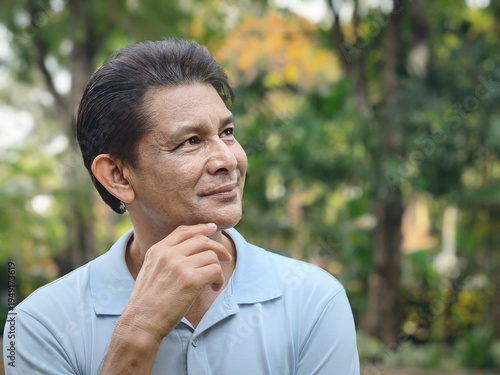 Asian senior man with white hair thinking, planning with happy positive optimistic facial expression, green city outdoor scene