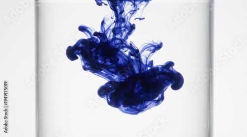 Blue Ink Swirls Rising in Clear Water Creating Abstract Patterns and Designs in a Glass on White Background