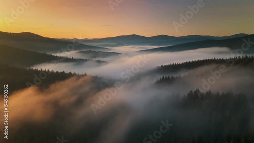 Rolling hill valley with morning mist and golden sunrise light over forested ridges and layered hills creating serene atmospheric landscape
