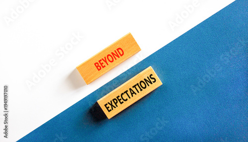 Beyond expectations words symbol. Concept words Beyond expectations on beautiful wooden blocks. Beautiful white and blue background. Business and Beyond expectations words concept. Copy space.