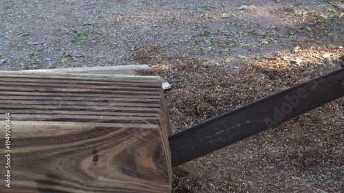 Sawing wood with a chainsaw.
