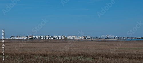 Fényképezés The townhouses and condominiums of Marsh Harbor at Toler’s Cove, with Ben Sawyer Memorial Bridge and Atlantic Intercoastal Waterway at right, and salt marsh in the foreground; Mount Pleasant, SC, USA