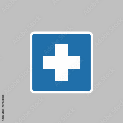 An emergency sign, featuring a white cross symbol on a blue background, indicating a medical facility or first aid assistance.