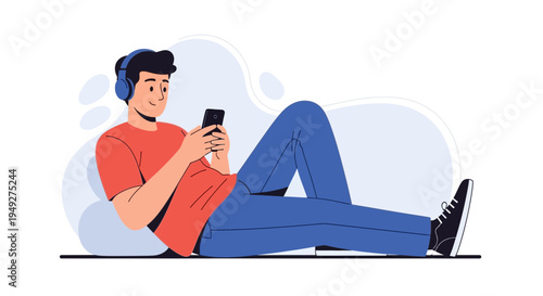 Young man listening to music on headphones and using smartphone, relaxing on floor