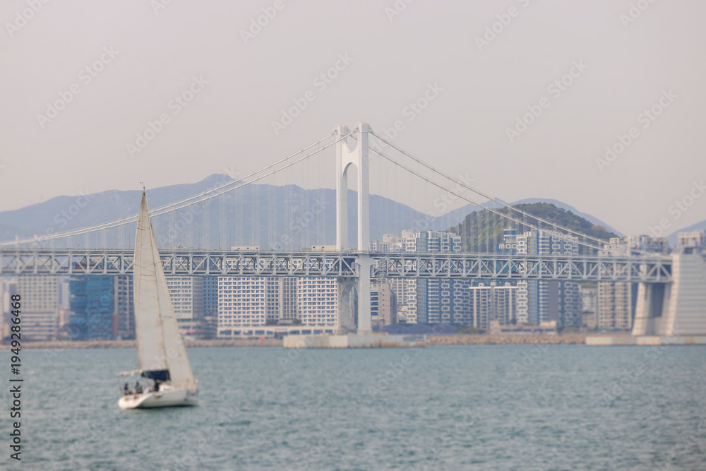 Obraz premium Busan Bay yacht boat cruise, Busan, South Korea, Yongho-dong, with Gwangan Diamond bridge, marina skyline and port harbor panorama, during boat excursion tour, Korean Strait, Haeundae river cruise
