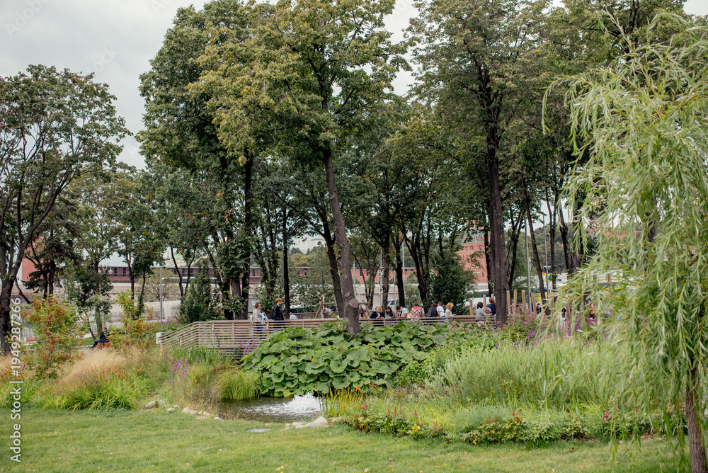 Obraz premium Moscow, Russia, August 17 2019: A serene urban park scene with trees and walking paths, perfect for relaxation