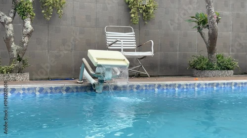 Swimming pool filtration system circulating clear blue water.