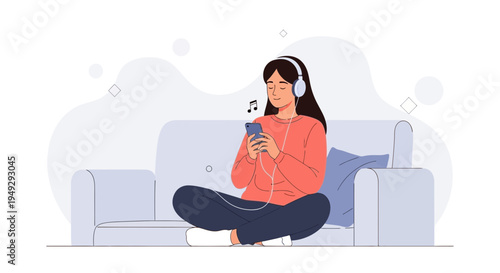 Young Woman Listening to Music on Phone with Headphones While Sitting on Sofa