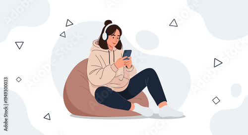 Young woman with headphones using smartphone while relaxing on bean bag chair