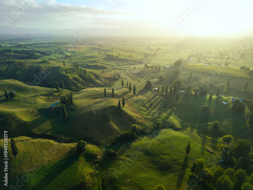 Drone aerial at sunrise over rolling hills of Hobbiton in New Zealand