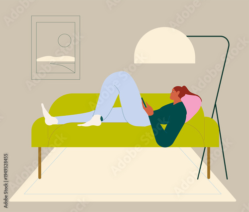 Woman lying on the couch at home, she is relaxing and connnecting online with her smartphone.