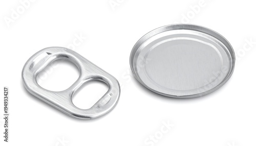 Detached soda can tab and lid on a white surface, showing metallic texture and simple circular, rectangular shapes